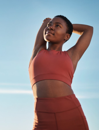 Une femme en tenue de sport s'étire.