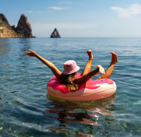 Une fille allongée sur une bouée à la mer.